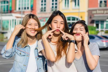 幸福的年幼的亚洲人女人组城市生活方式演奏和查廷