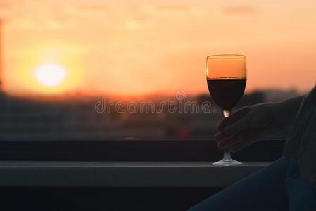轮廓关于女性的手和玻璃关于红色的葡萄酒向指已提到的人日落英语字母表的第20个字母