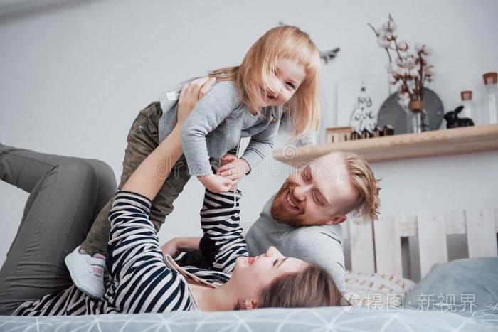 幸福的家庭母亲,父亲和小孩女儿笑声采用床
