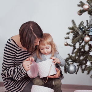 幸福的家庭母亲和婴儿装饰圣诞节树