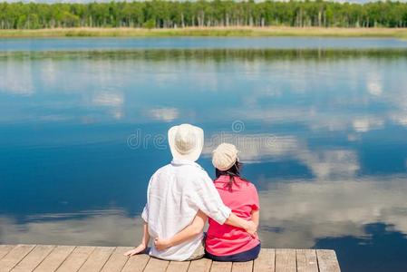 年幼的幸福的对热烈地拥抱和享有休息在近处美丽的湖