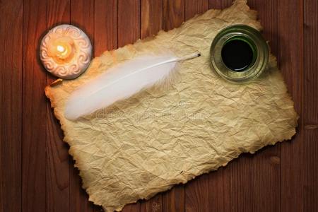 白色的羽毛和墨水罐,蜡烛和老的辗关于纸照片