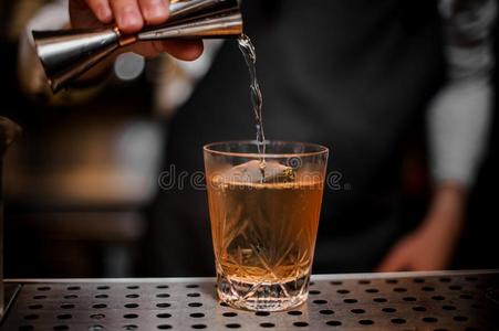 酒吧间销售酒精饮料的人倒酒一酒精的喝从一me一suring杯子照片