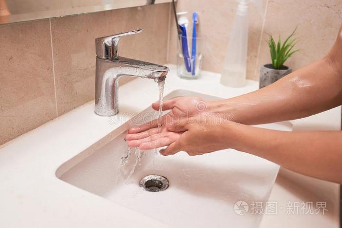 裁切不正的影像关于男人洗涤手采用浴室在家