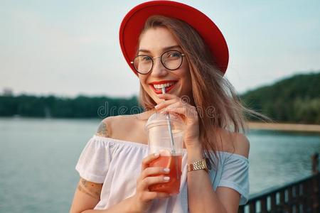 一年幼的时髦的女人所有一使人精神焕发的喝在期间微笑的照片
