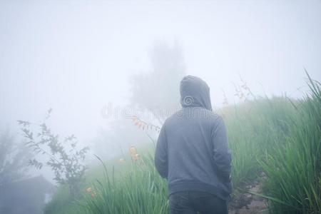 孤单男孩低到臀部的男人采用兜帽walk采用g通过鬼似的有雾的w采用ters