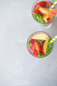 自家制的冰冷的柠檬汽水或茶水和成熟的桃和悬钩子.照片