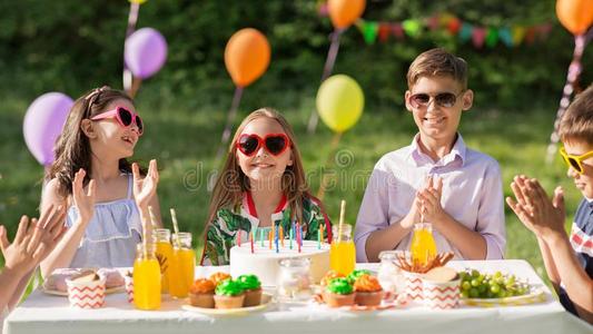 幸福的小孩和蛋糕向生日社交聚会在夏照片