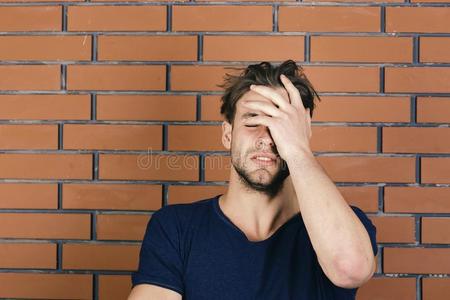 家伙和微小的鬃毛采用黑暗的蓝色t恤受痛苦从头痛照片