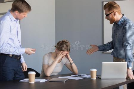 生意失败生气的生意人喊叫在女性的同事指责为失败照片