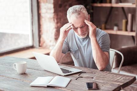 肖像关于情绪低落的上了年纪的男人令人同情的他的庙照片