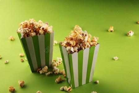 爆米花袋电影院观念和爆米花采用绿色的白色的袋.照片