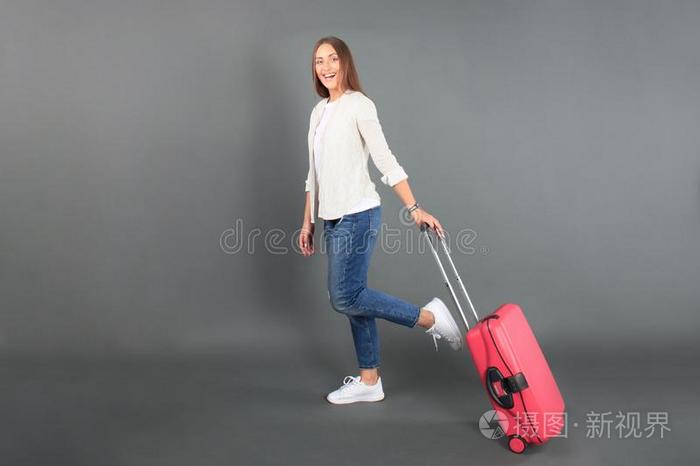 年幼的旅行者女孩采用夏偶然的衣服,和红色的手提箱,