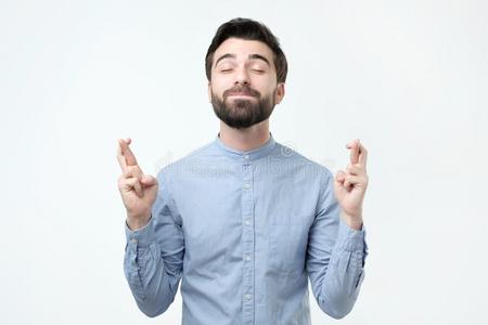 交互手势西班牙的男人起立和十字的手指和关闭着的眼睛,homeaudio