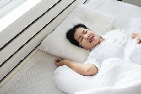 亚洲人上了年纪的女人打呼噜因为由于向疲倦的关于使工作,女性的照片