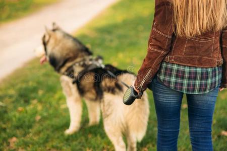白肤金发碧眼女人女孩步行和嗓子哑的狗.背看法照片
