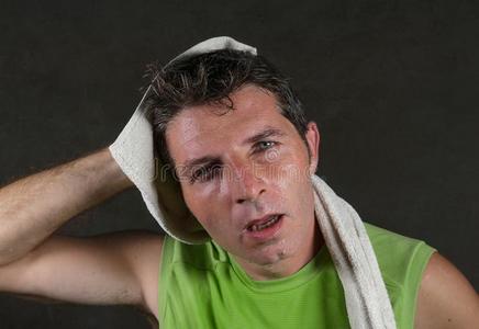 年幼的疲倦的和耗尽的运动男人和毛巾向他的颈流汗照片