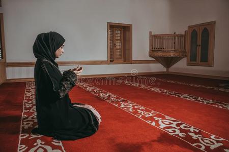 穆斯林女人祈祷采用清真寺照片
