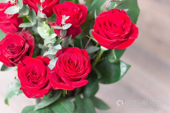 关-在上面.花束红色的玫瑰向白色的木制的背景