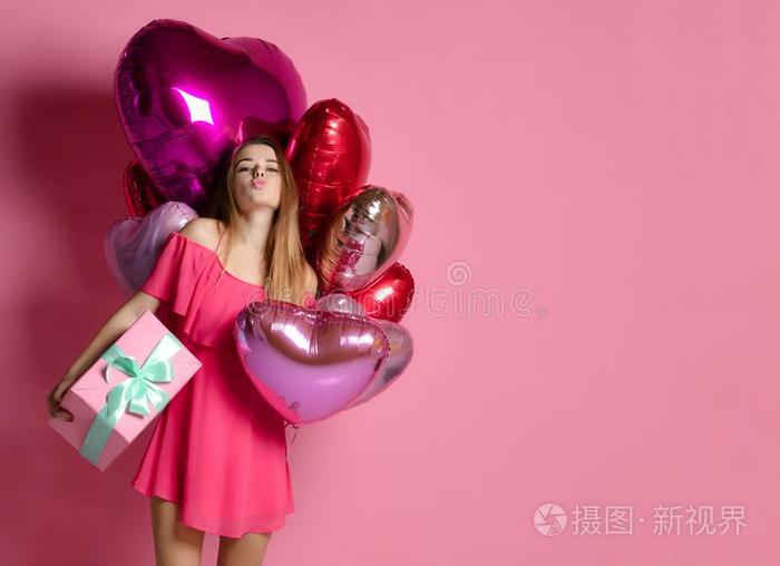 情人美好女孩拿住红色的和粉红色的天空气球笑的向