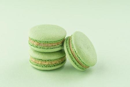 垛关于绿色的阿月浑子树马卡龙向同一的颜色背景照片