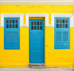 蓝色和黄色的门蓝色门和窗向黄色的墙照片