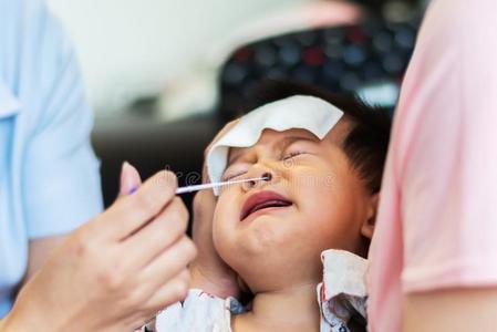 宝宝流鼻涕婴儿小孩害怕的关于护士使用棉芽收集小的婴儿switzerland