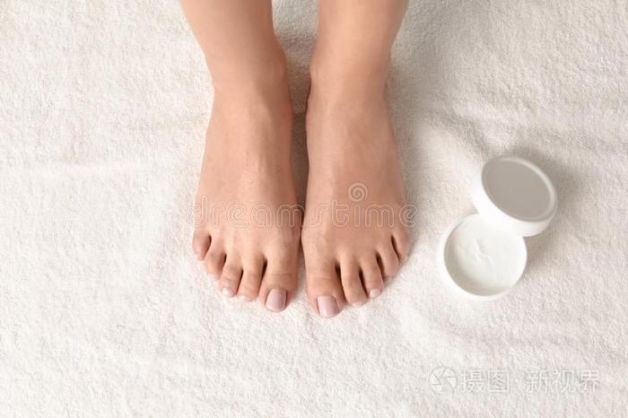 女人和美丽的脚和罐子关于给增加水分乳霜向白色的