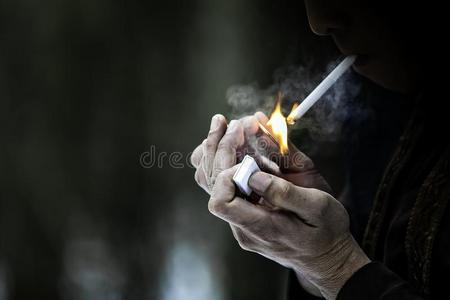 成瘾癌症关在上面男人吸烟一cig一rette打火机和m一tches和粗糙的照片