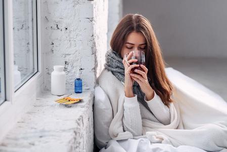 恶心的不健康的女人喝饮料准备动作的喝在室内.寒冷的和flores花照片