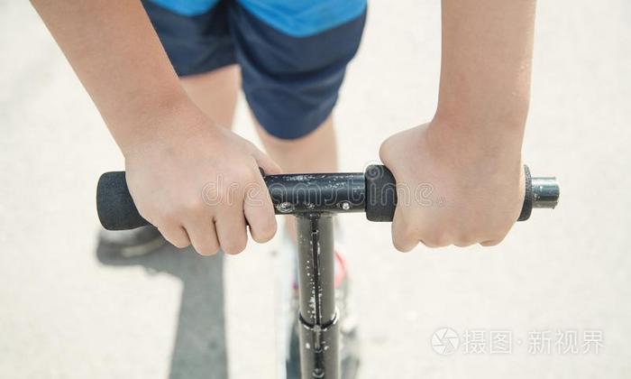 男孩向一小型摩托车骑马向指已提到的人大街