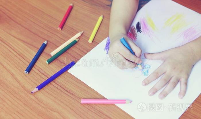 女孩绘画向纸纸和颜色铅笔向指已提到的人木制的英语字母表的第20个字母