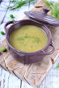 蔬菜煮成浓汤汤和芦笋和绿色的豌豆形成顶部和照片