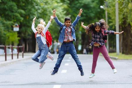 混合的种族的组幸福的孩子们用于跳跃的采用指已提到的人公园在近处
