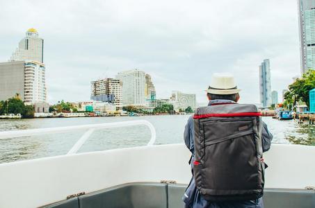 同行的背着背包徒步旅行的人向小船高兴有样子的城市风光照片采用照片
