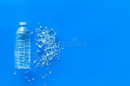 空的塑料制品瓶子为纯的水和冰立方形的东西向蓝色背照片