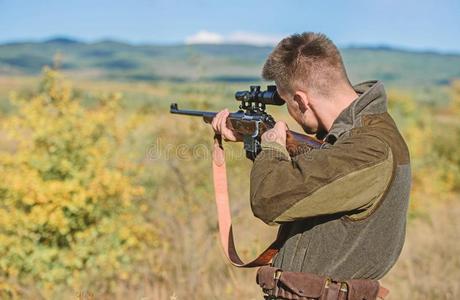 猎人拿住步枪瞄准.向我的对象.有胡须的猎人用钱花环照片