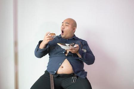亚洲人秃头的肥的男人和大的肚子幸福的采用食物照片