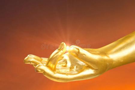 金色的手关于佛雕像和透镜闪耀在手指照片