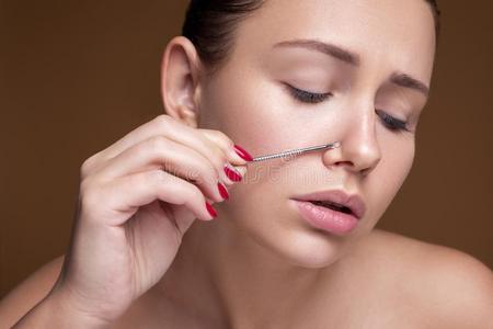 黑头发的妇女高加索人女人挤痤疮.关在上面肖像关于面容照片