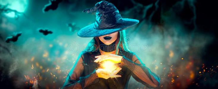 魔法女巫万圣节前夕女巫女孩和制造巫术,魔法采用她手,照片