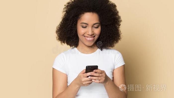 幸福的代表两种人种的一千年的女孩微笑使用现代的蜂窝式便携无线电话