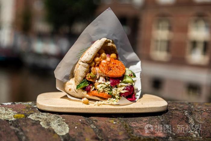 可爱的沙拉三明治皮塔饼向一木制的pl一te在外面向一砖w一ll