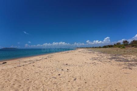 无人居住的沙的海滩在下面一蓝色天照片