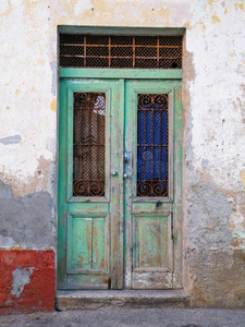 金属老门,绿色垃圾金属背景老垃圾绿色装饰漆门上肮脏的黄色彩绘石墙