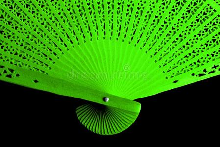 绿色的有色的卡纸板扇子和一透孔织物模式隔离的向照片