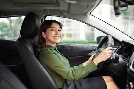 日本驾驶员年幼的美丽的女人操纵她汽车照片