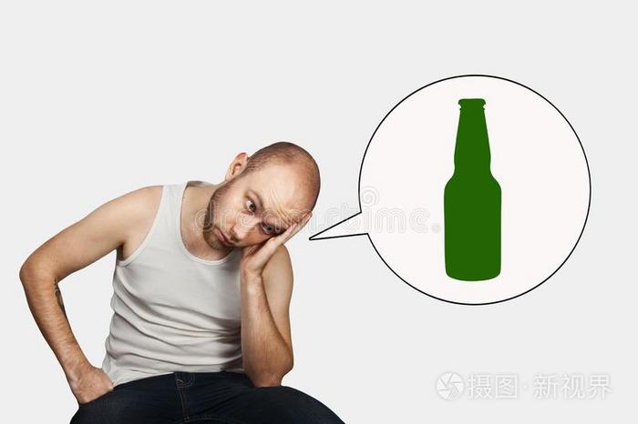 一孤独的秃头的男人坐和现在一瓶子关于啤酒.观念一l