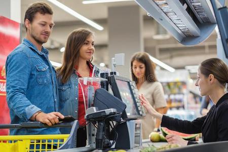出纳高加索人对购买商品采用一食品杂货店商店照片