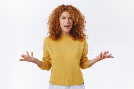 厌烦的,烦恼的红发的人女性的和有卷发的头发,穿着黄色的英文字母表的